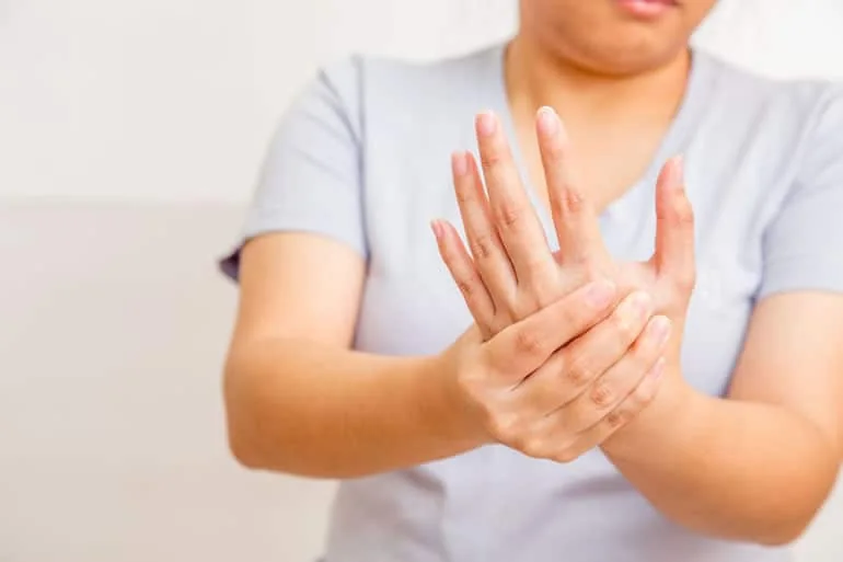 Woman holding her sore wrist and hand