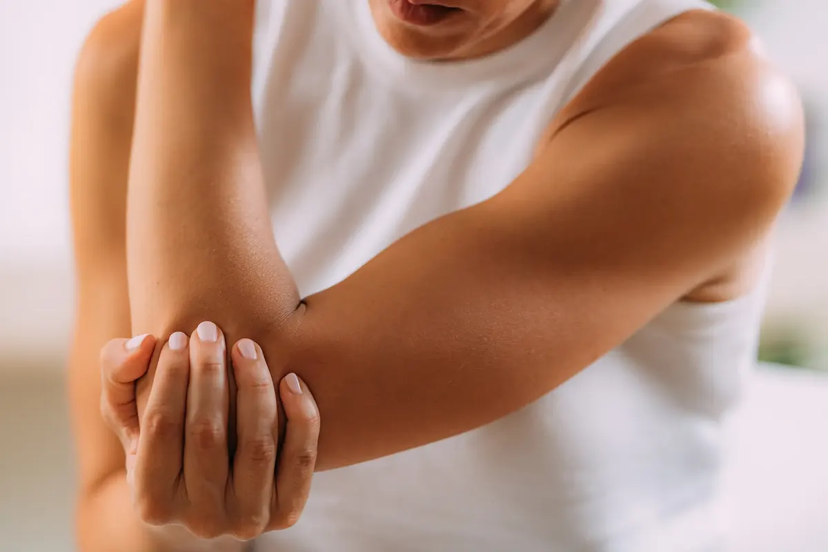 Woman holding her painful elbow